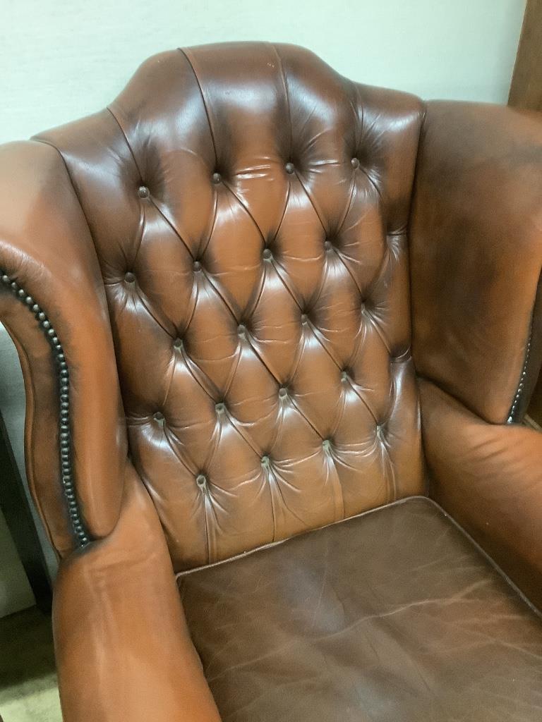 A buttoned burgundy leather wing armchair, width 86cm, depth 80cm, height 110cm